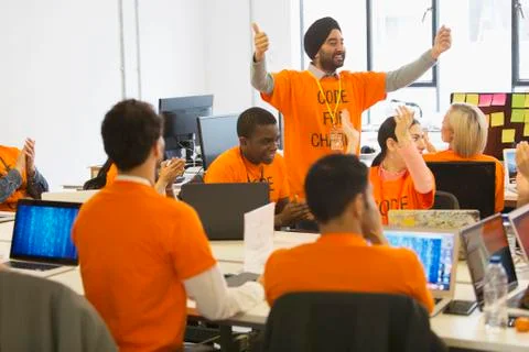 Hackers cheering, coding for charity at hackathon Stock Photos