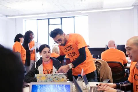 Hackers coding for charity at hackathon Stock Photos