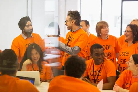 Hackers coding for charity at hackathon Stock Photos