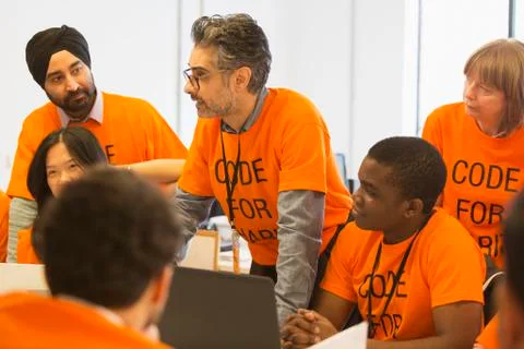 Hackers coding for charity at hackathon Stock Photos