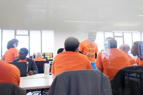 Hackers coding for charity at hackathon 写真素材