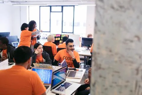 Hackers coding for charity at hackathon Stock Photos