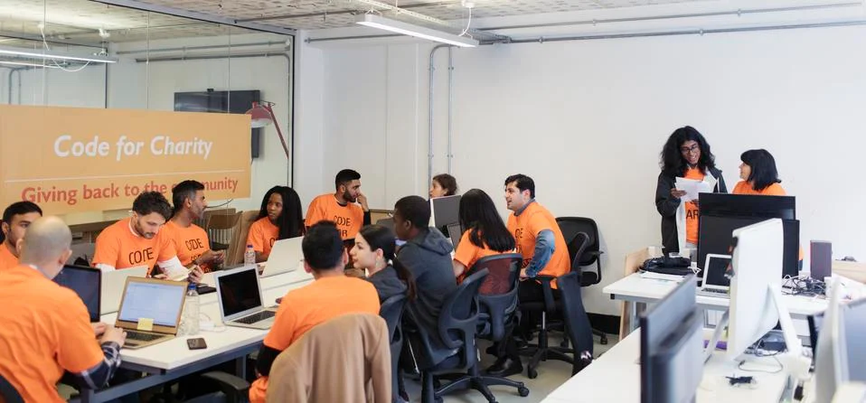 Hackers coding for charity at hackathon Stock Photos