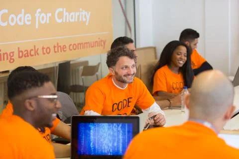 Hackers coding for charity at hackathon Stock Photos