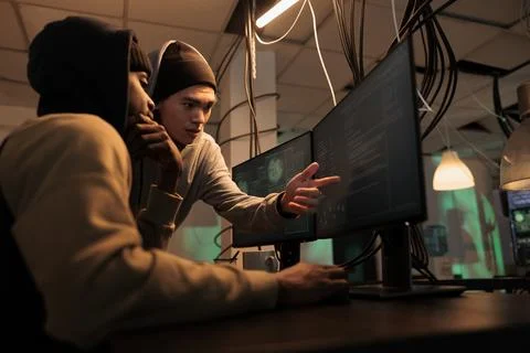 Hackers discussing computer system hacking, coding malicious software Foto stock