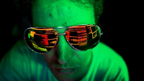 Hacker's glasses reflecting malicious code on screen. Stockbeeldmateriaal 116904260