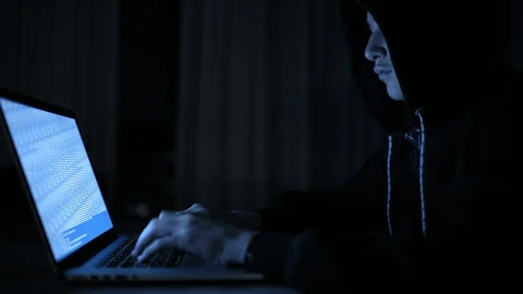 Hacker's hacking into the computer network. A young guy in a dark room typing Stock Footage 106021827