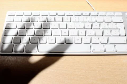 Hackers hand hovering over a computer keyboard Stock Photos