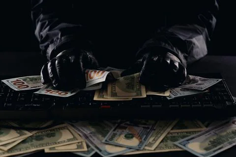 Hackers hands on a computer keyboard rake in money Stock Photos