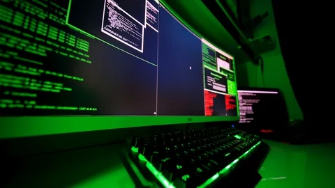 Hacker's hands typing malicious code into keyboard on large screen. Stock Footage 116898498