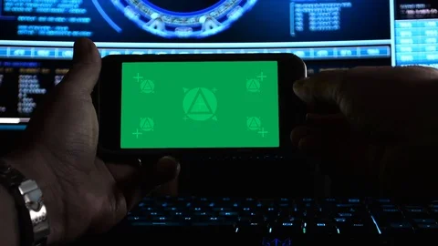 Hackers hands using a smartphone (landscape) in front of hi-tech screens, Stock Footage 107589133