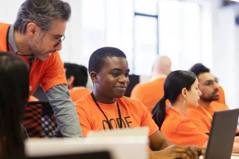 Hackers at laptops coding for charity at hackathon 스톡 사진