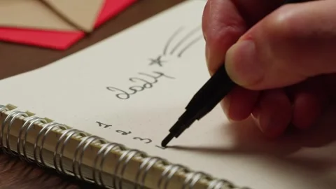 Hads writting some goals, purposes on list on wooden desk surrounded by Stock Footage 255228317