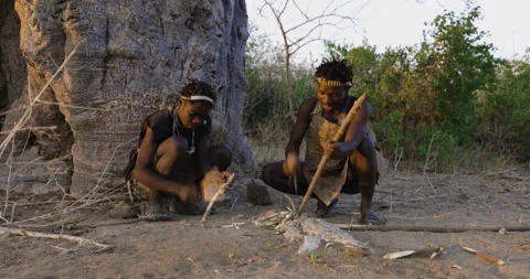 Hadza hunter-gatherer tribesmen making a spear in the traditional way Tanzania Stock Footage 160907854