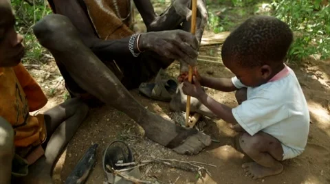 Hadzabe tribe man making fire by rubbing two sticks Stock Footage 49011553