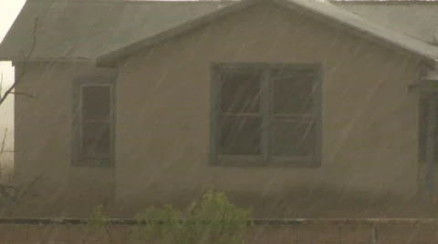 Hail and heavy rain falling in front of run down house Stock Footage 504112