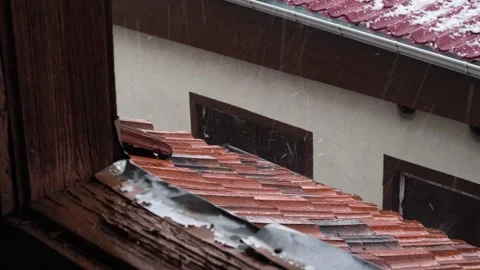 Hail and rain are falling on the briquette roof of the old house Video stock 277541055