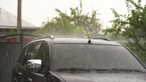 Hail during heavy rain falls on roof and windshield of black car Vidéo 196816780