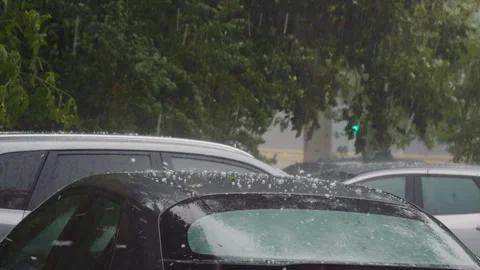 Hail during heavy rain falls on roof and windshield of black car. Stock Footage 295775371