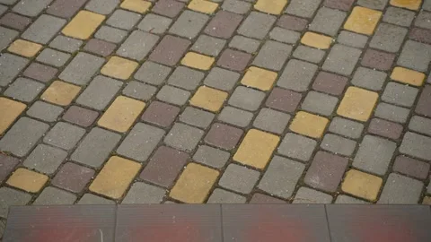 Hail icicles fall and bounce on paving slabs near steps on cloudy day. Stock Footage 240242053