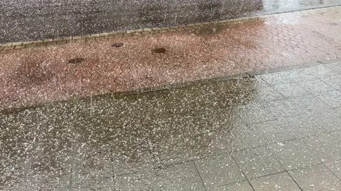 Hail weather extreme falling down on footpath and street at spring season day Stock Footage 157331086