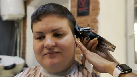 A hair clipper in the hands of a master as a tool for creating a short hairstyle Stock Footage 258050614