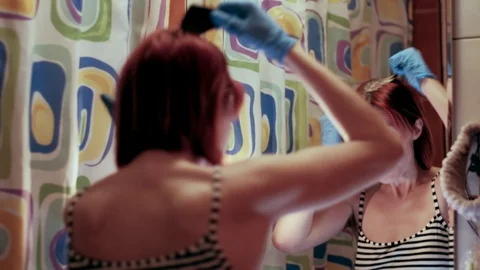 Hair coloring. Hair dyeing. Thin Woman hairdresser caucasian during self-isolati 스톡 동영상 129008053