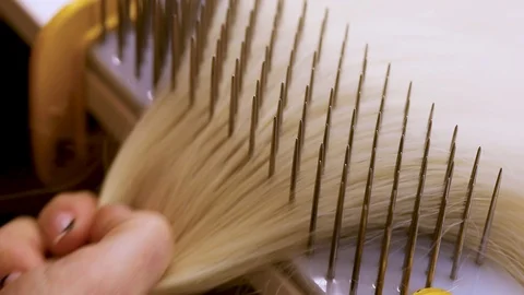 Hair combing when creating a wig. Factory wig production process Stock Footage 124373288