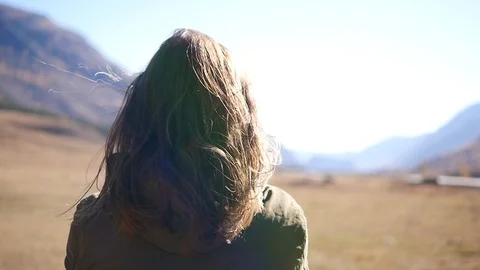Hair develops in the wind against the backdrop of mountains and steppe. Travel 動画素材 98027996