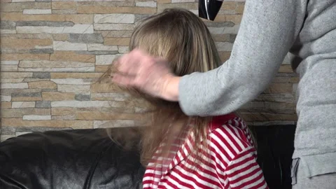 Hair drying process. Mom dries hair with hairdryer of blonde daughter Stock Footage 150299532
