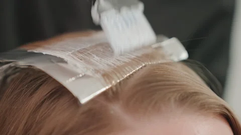 Hair foil application, Closeup view of hairstylist working with foil at salon Stock Footage 325092469