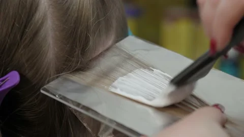 Closeup Of A Strand Of Female Hair On A Special Sheet Of Foil The Master  Applies Hair Dye With A Brush The Process Of Highlighting By A Professional  Master In A Beauty