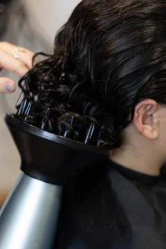 Hair styling process with diffuser in salon setting Stock Photos