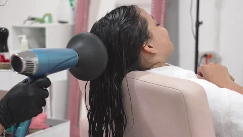 Hair stylist using diffuser on curly hair of girl at salon, Beauty and Wellness Video stock 311058254