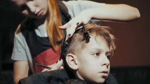 Haircut for boy scissors and comb at the hairdresser. Stock Footage 103383293