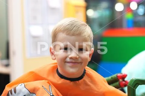 Haircut of a little boy in a children's hairdressing salon Stock Photos