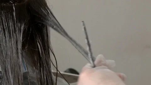 Hairdresser at the beauty salon, dyes her hair young woman Stock Footage