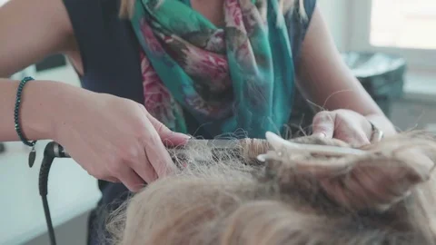 Hairdresser in the process of doing curls, using a curling iron Video stock 74442821