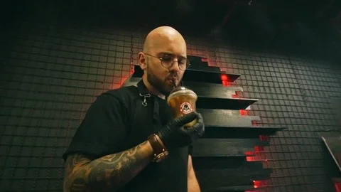Hairless Man with beard drinking soft drink with bat in hand Stock Footage 115699479