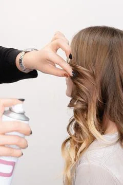 A hairstyle master makes styling for a young girl model Stock Photos