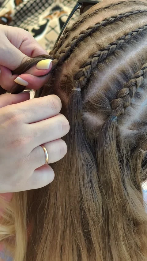 Hairstylist Creating Thin Cornrow Braids on Brown Hair Stock Footage 314999469