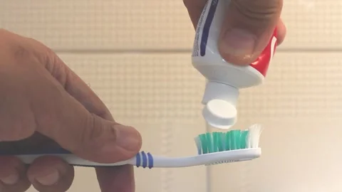 Hairy man putting toothpaste on a toothbrush against the backdrop of a cerami Stock Footage 305360101