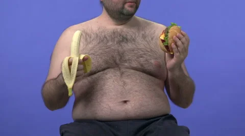 Hairy overweight man choosing between banana and hamburger. Stock Footage 45926387