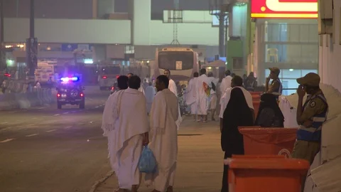 Hajj pilgrims in Ihram stand by the side of road in Mina Stock Footage 86760068