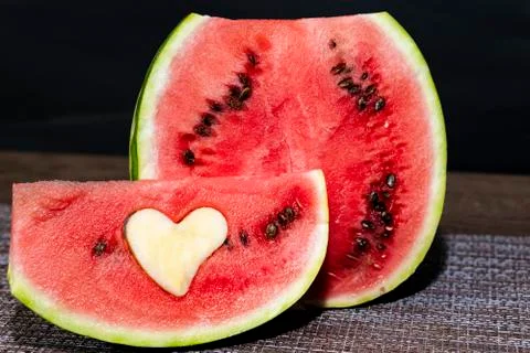 Half and separate slice of red watermelon on a wooden table. Paper heart on the Stock Photos