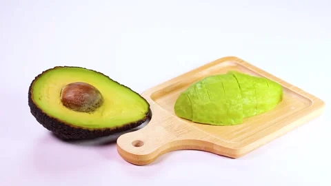 Half and sliced ​​avocado on white background, rotating Stock Footage 319412873