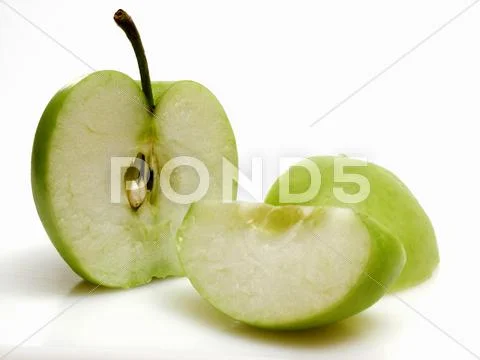 Half and Wedges of Granny Smith Apple Stock Photos