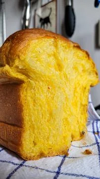 A half of appetizing handmade pumpkin bread on a white blue kitchen towel. Stock Photos