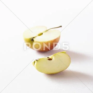 Half an apple and a wedge of apple Stock Photos