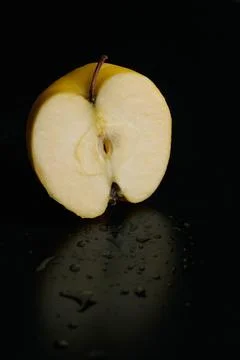 Half of apple on a black background Stock Photos